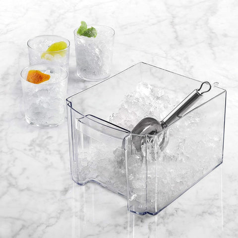 Contenitore trasparente con ghiaccio tritato fine e paletta in acciaio inox, bicchieri con agrumi per cocktail e bevande fresche