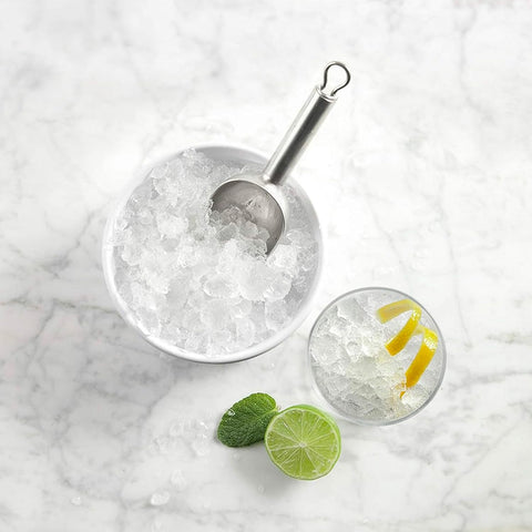 Secchiello ghiaccio con paletta in acciaio inox, cocktail con lime e menta su superficie marmo, perfetto per bar casalingo