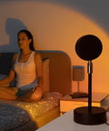 Donna in relax e meditazione con lampada proiettore tramonto in camera da letto, atmosfera romantica e rilassante per benessere