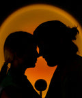 Coppia romantica in silhouette con lampada proiettore tramonto che crea atmosfera intima e romantica, perfetta per momenti d'amore